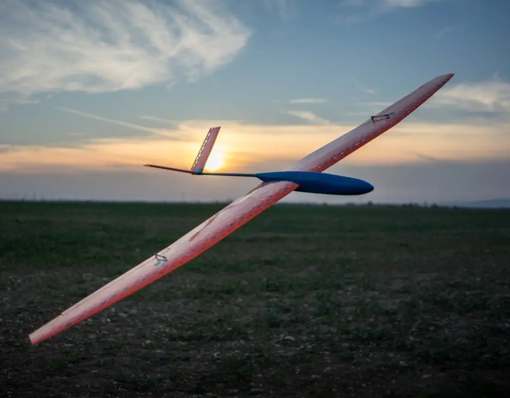The Kraga Kodo 3D printed plane flying over green grass during a sunset